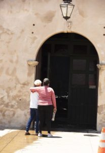 Los feligreses de la Misión de San Gabriel lloran  afuera de la puerta de la iglesia dañada el 11 de julio. (Víctor Alemán)