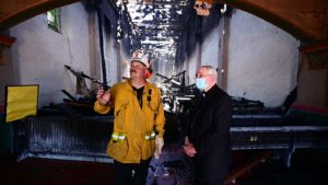 El arzobispo José H. Gomez y el jefe de bomberos de San Gabriel Steve Wallace inspeccionan los daños a la Misión de San Gabriel la mañana del 11 de julio. (Noticias - John McCoy/Angelus)