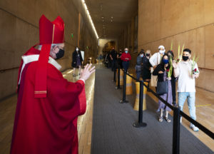 Monseñor Gómez saluda a los asistentes a la misa del Domingo de Ramos a la salida de la catedral. (Víctor Alemán)

