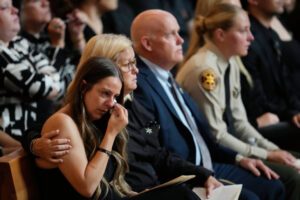 Brittany Lindsey, a la izquierda, prometida del ayudante del sheriff de Los Ángeles Ryan Clinkunbroomer, se seca las lágrimas junto a la madre de Clinkunbroomer, Kim, segunda por la izquierda, durante una misa funeral por el ayudante caído en la Catedral de Nuestra Señora de los Ángeles el jueves 5 de octubre de 2023, en Los Ángeles. Clinkunbroomer fue asesinado a tiros el 16 de septiembre mientras estaba sentado en su coche patrulla en Palmdale. (AP Photo/Ashley Landis, Pool)
