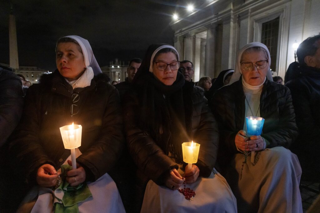 Monjas sostienen velas mientras se unen al cardenal Víctor Manuel Fernández, prefecto del Dicasterio para la Doctrina de la Fe, para el rezo del rosario por el Papa Francisco en la Plaza de San Pedro en el Vaticano el 28 de febrero de 2025. El Papa Francisco está hospitalizado desde el 14 de febrero por una doble neumonía. (CNS photo/Pablo Esparza)
