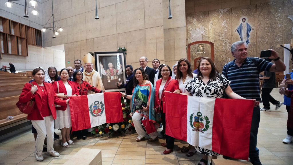 Un grupo de fieles peruanos posa con el arzobispo José H. Gómez en torno a un retrato del Papa León XIV tras una misa especial de celebración del nuevo pontífice el 9 de mayo. (Víctor Alemán)