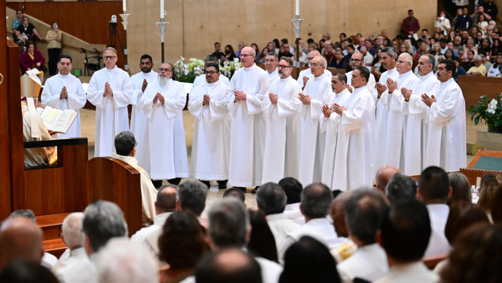 Los 18 hombres ordenados como diáconos permanentes frente al arzobispo José H. Gomez durante la Misa de ordenación en la Catedral de Nuestra Señora de los Ángeles, el 7 de junio. (John McCoy)