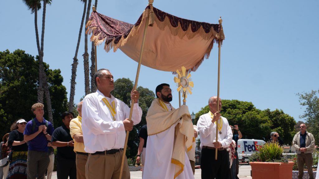 El padre Eduardo Pruneda, vicario parroquial en la Misión Basílica San Buenaventura, entra en procesión con el Santísimo Sacramento antes de la Misa del viernes 20 de junio de 2025. La Misa fue una de varias celebradas durante el último fin de semana de la Peregrinación Eucarística Nacional. (Katie Trejo)
