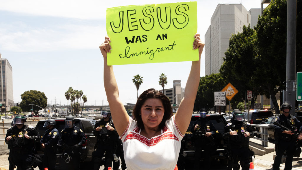 Una mujer sostiene un cartel frente a la salida de una autopista cerrada durante las protestas a favor de los inmigrantes, el 14 de junio de 2025, en el centro de Los Ángeles. | VÍCTOR ALEMÁN
