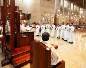 Los ocho hombres que ingresan al sacerdocio de pie ante el Arzobispo José H. Gómez durante la Misa de ordenación en la Catedral de Nuestra Señora de los Ángeles el 31 de mayo. (Víctor Alemán)