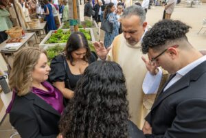 DSC_6378 | Angelus en Español El diácono Ariel Santiago ofrece su primera bendición a su esposa Amalia, a su hija mayor Daisy Sánchez, a su hijo Ariel Jr., y a su hija menor Narelly, en la plaza exterior de la catedral tras la Misa de ordenación. (John McCoy)