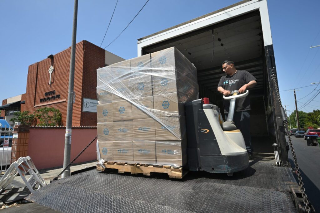 Un trabajador de Labor Community Services Los Angeles entrega donaciones en la Iglesia de San Patricio, cerca del centro de Los Ángeles. (John McCoy)