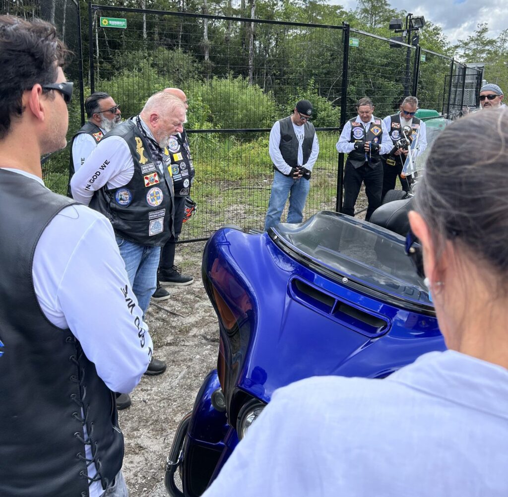 El arzobispo de Miami, Thomas G. Wenski, y los Caballeros en Bicicleta rezan el rosario por los detenidos a la entrada de Alligator Alcatraz, un controvertido centro de detención de inmigrantes situado a unas 55 millas de Miami, en los Everglades de Florida, el 20 de julio de 2025. (OSV News photo/Arzobispo Thomas G. Wenski)