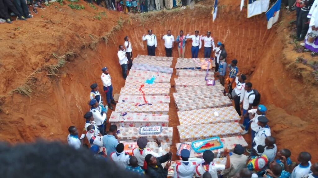 Unos hombres rodean los ataúdes durante un entierro en Komanda, en la provincia congoleña de Ituri, el 28 de julio de 2025, de las víctimas de un horrible ataque a la iglesia católica de Komanda, donde al menos 43 fieles fueron asesinados a tiros o a machetazos durante una vigilia nocturna en la iglesia el 27 de julio. (OSV News/cortesía del padre Justin Zanamuzi)