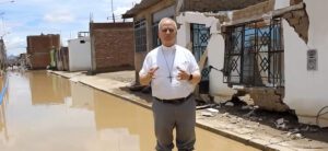 Screenshot | Angelus en Español El obispo Prevost a menudo desafiaba el agua y el barro para repartir ayuda y suministros durante las inundaciones de 2017 en Perú causadas por El Niño. (Captura de pantalla vía YouTube)