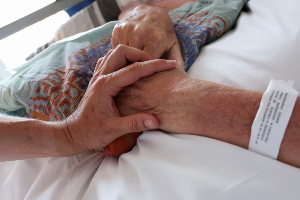 Una enfermera toca la mano de un paciente en la unidad de cuidados paliativos de la Clínica Saint-Elisabeth en Marsella, Francia, el 31 de mayo de 2024. En un comunicado del 13 de agosto de 2025, la Conferencia Episcopal del Uruguay expresó su pesar tras la aprobación por parte de la Cámara de Diputados de un proyecto de ley que despenaliza la eutanasia. (Foto OSV News/Manon Cruz, Reuters)