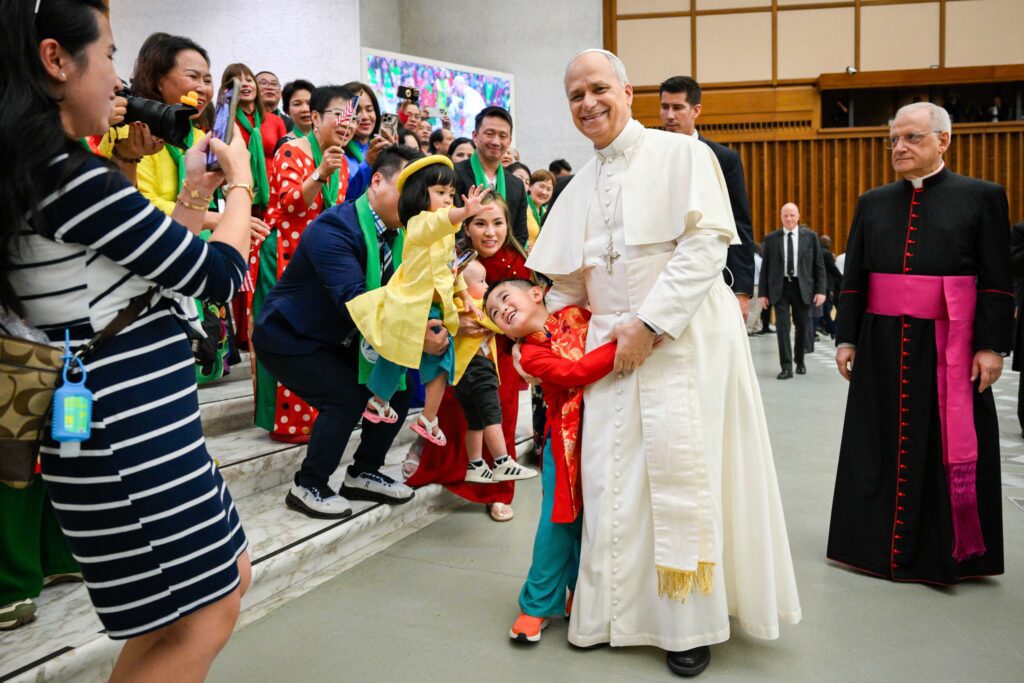 El papa León XIV saluda a niños y familias vestidos con trajes tradicionales durante su audiencia general semanal en la Sala de Audiencias Pablo VI del Vaticano, el 27 de agosto de 2025. (Foto CNS/Vatican Media)