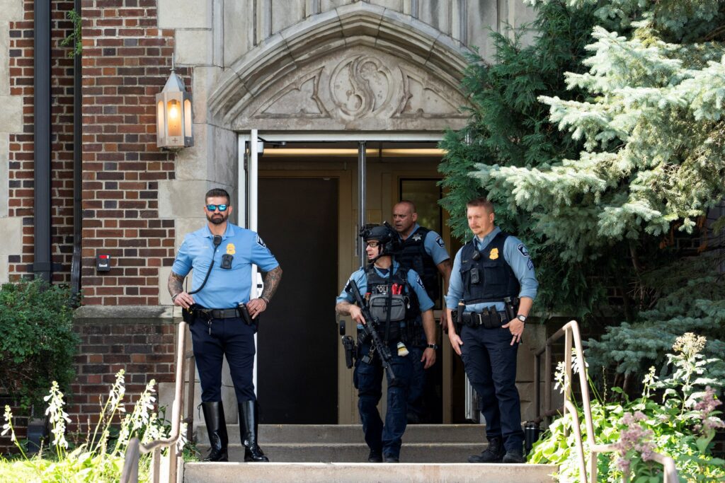 Tras un tiroteo, los socorristas permanecen en la entrada de la escuela católica Annunciation de Minneapolis el 27 de agosto de 2025. Un tirador abrió fuego con un rifle a través de las ventanas de la iglesia de la escuela y atacó a los niños en la Misa durante la primera semana de clases, matando a dos e hiriendo a 17 personas. (Foto OSV News/Tim Evans, Reuters)