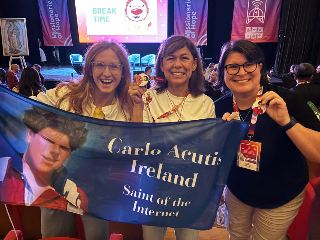 Josefina Fernández McEvoy, al centro, posa junto a Mary Aoife (izquierda), de Irlanda, y Angie Bosio (derecha), de Tennessee, mientras sostienen una pancarta del próximo santo Carlo Acutis durante el primer Jubileo de Misioneros Digitales e Influencers Católicos en Roma.