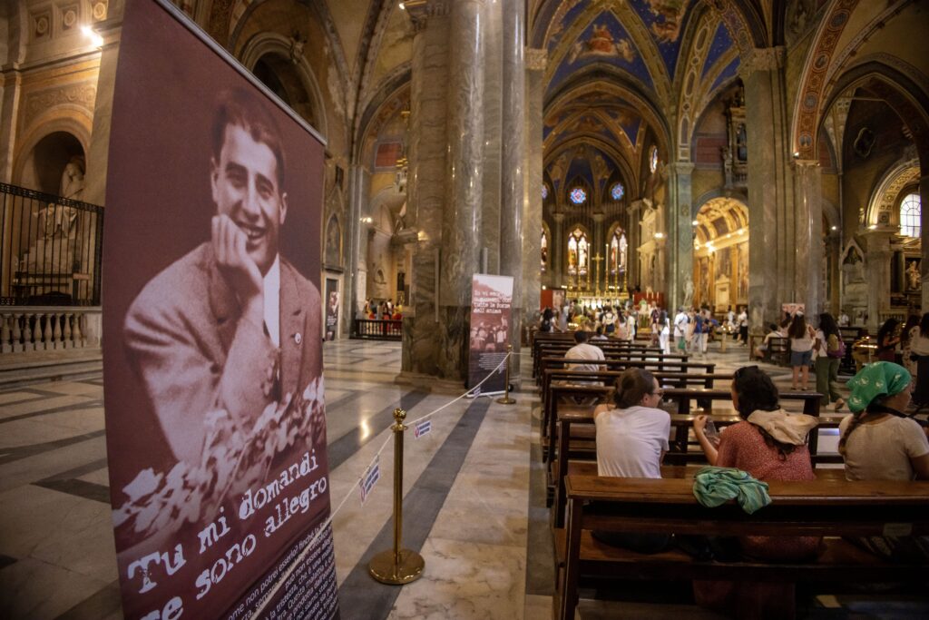 Los peregrinos visitan la Basílica de Santa María sopra Minerva en Roma el 31 de julio de 2025, donde se han trasladado las reliquias del beato Pier Giorgio Frassati con motivo del Jubileo de la Juventud. Las pancartas dentro de la basílica muestran imágenes y citas del beato, cuyo ataúd con sus restos fue trasladado desde su tumba en Turín para su veneración. (Foto CNS/Pablo Esparza)