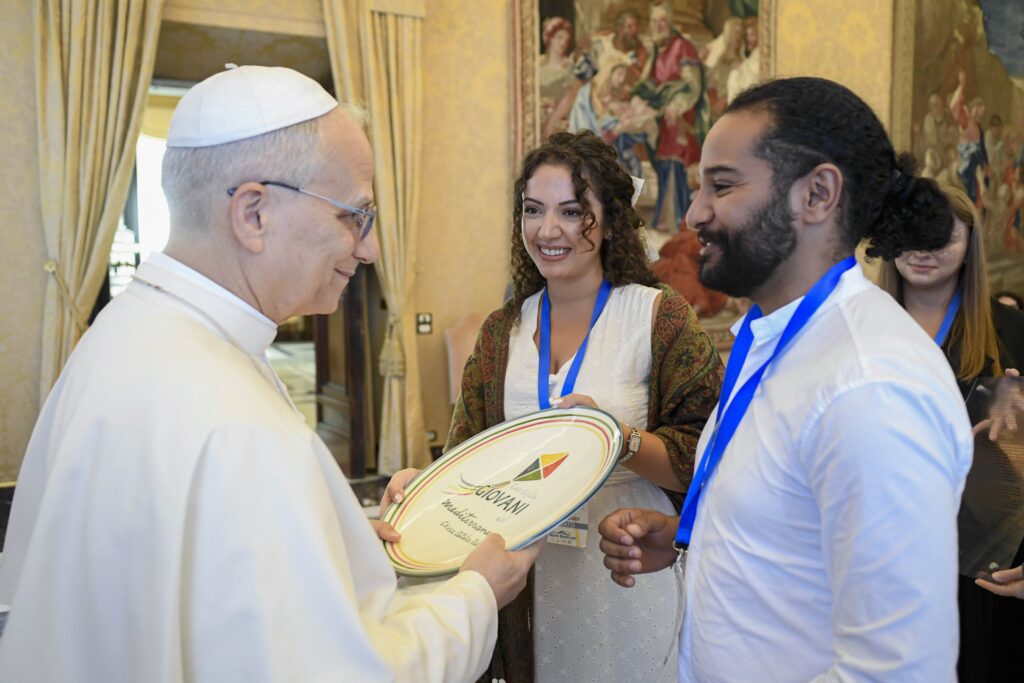 Jóvenes adultos obsequian al papa León XIV con un plato decorado con el logotipo del Consejo Juvenil del Mediterráneo tras una audiencia en el Vaticano el 5 de septiembre de 2025. El consejo, coordinado por los obispos italianos, incluye a representantes jóvenes adultos de más de una docena de países mediterráneos. (Foto CNS/Vatican Media)