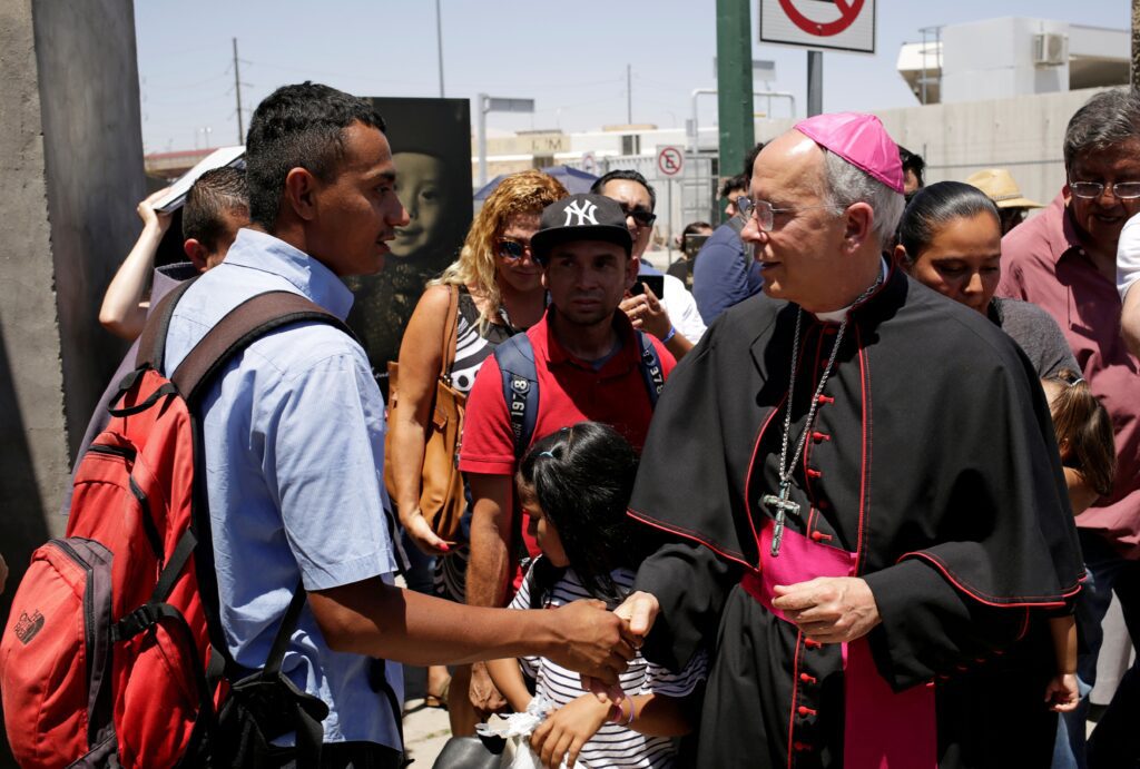 El obispo Mark J. Seitz, de El Paso (Texas), saluda a un migrante salvadoreño en Ciudad Juárez (México), el 27 de junio de 2019, que fue deportado de Estados Unidos tras cruzar la frontera internacional Paso del Norte desde El Paso. (Foto de OSV News/José Luis González, Reuters)