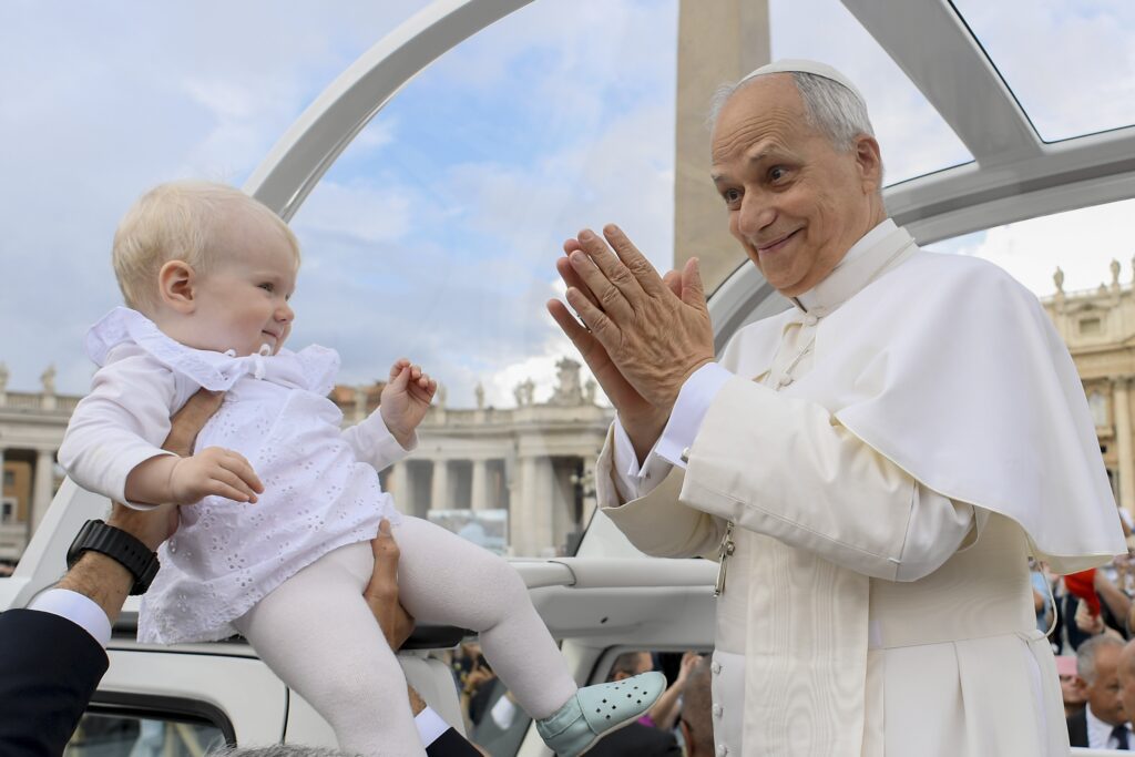 El papa León XIV saluda a un niño mientras recorre la plaza de San Pedro en el Vaticano en el papamóvil antes de su audiencia general semanal el 24 de septiembre de 2025. (Foto CNS/Vatican Media)
