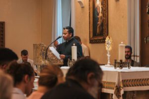 El padre Juan Gutiérrez, sacerdote de Los Ángeles, dirige las oraciones durante una vigilia previa a la canonización en la Pontificia Universidad Gregoriana de Roma. La curación repentina de su tendón de Aquiles desgarrado fue reconocida como el segundo milagro verificado necesario para la canonización de Frassati. (Isabel Cacho/Arquidiócesis de LA)