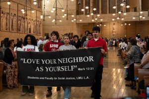 Estudiantes de Loyola Marymount University participan en la procesión de entrada durante la Misa en Reconocimiento a Todos los Inmigrantes en la Catedral de Nuestra Señora de los Ángeles, el 21 de septiembre. (Evan Lirette)