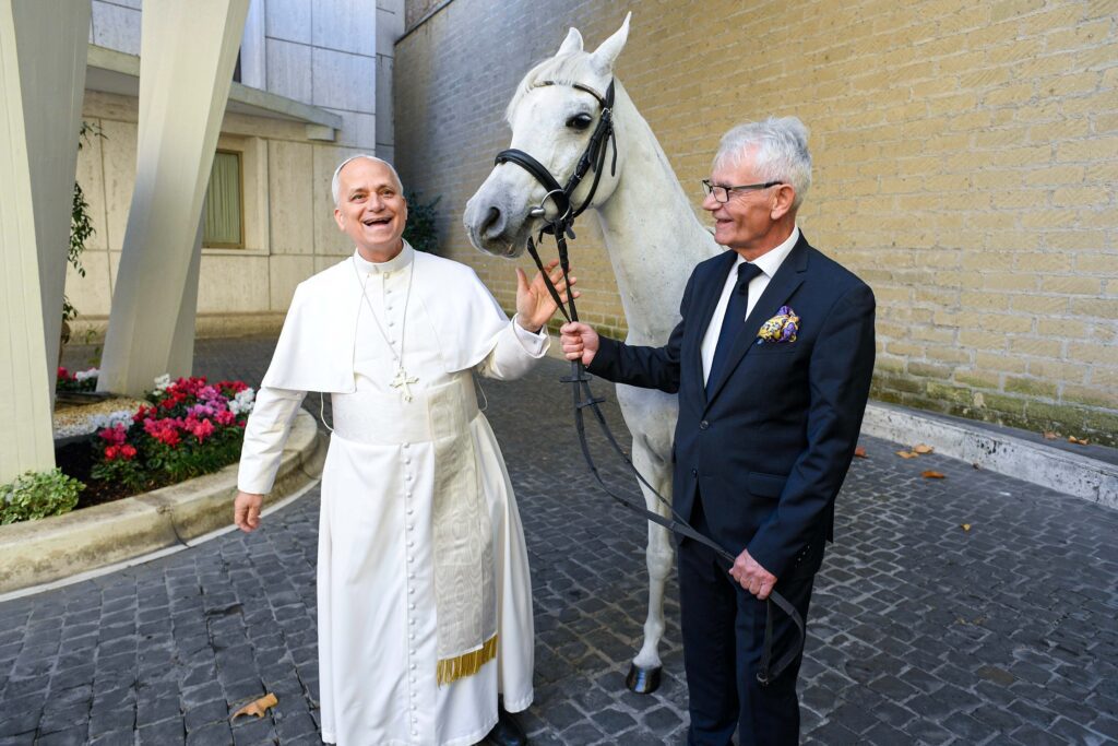 El papa León XIV sonríe al recibir un caballo árabe de pura raza donado por un criador de caballos polaco en el Vaticano el 15 de octubre de 2025. El papa solía viajar a caballo cuando era misionero en Perú. (Foto CNS/Vatican Media)