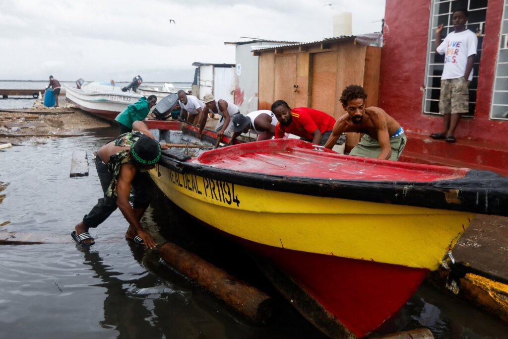 HURRICANE MELISSA JAMAICA PREPARATION | Angelus en Español Pescadores jamaicanos trasladan un barco a un terreno más elevado, en preparación para el huracán Melissa en Port Royal, el 26 de octubre de 2025. El huracán Melissa se intensificó hasta alcanzar la categoría 5 el 27 de octubre, al acercarse a Jamaica con hasta 76 cm de lluvia y una marejada ciclónica que ponía en peligro la vida. (Foto de OSV News/Octavio Jones, Reuters)