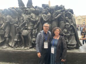 Rosa_and_Carlos_Bonilla_Angels_Unaware-1536x1152 | Angelus en Español Rosa Bonilla, derecha, y su esposo, Carlos, posan frente a la escultura “Ángeles sin saberlo” en la Plaza de San Pedro en Roma. (Ellie Hidalgo)