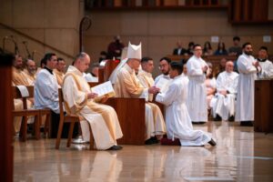 02-1536x1025 | Angelus en Español El futuro diácono Jerick Alenton se arrodilla frente al obispo auxiliar Slawomir Szkredka, quien presidió la Misa de ordenación. (John Rueda)