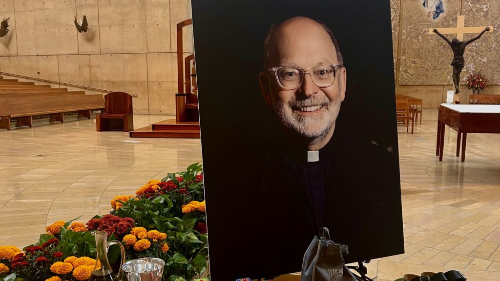 Una mesa con objetos personales del padre Chris Ponnet, incluidas sus sandalias de caminar, fue colocada junto a su retrato durante su funeral del 4 de noviembre en la Catedral de Nuestra Señora de los Ángeles. (Tom Hoffarth)