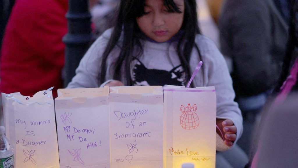 Zuanny, de ocho años, coloca luminarias con mensajes sobre su madre, una "soñadora" del programa DACA, sobre ella misma y sobre sus hermanas durante una vigilia en La Colaborativa, en Chelsea, Massachusetts, el 10 de octubre de 2025, en apoyo a la comunidad afectada por las redadas y detenciones del Servicio de Inmigración y Control de Aduanas. (OSV News/Brian Snyder, Reuters)