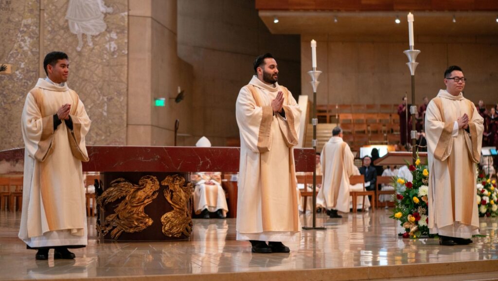 Nuevos diáconos Jerick Alenton, David Zamora y Shengda Zhu de pie en el altar durante la Misa de ordenación al diaconado transitorio en la Catedral de Nuestra Señora de los Ángeles el 22 de noviembre. (John Rueda)