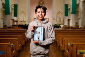 Ezekiel_Ponce__-_3-1024x682 | Angelus en Español Ezequiel Ponce, de 17 años, con un retrato digital del Papa León XIV en el interior de la iglesia Our Lady of Perpetual Help en Downey. (Reese Cuevas)