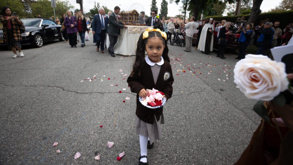 Una alumna de la escuela carmelita Santa Teresita en Alhambra esparce pétalos de rosa ante las reliquias de la santa durante la procesión hacia la Casa de Retiro Sagrado Corazón, el 13 de octubre. (Jeffrey Bruno)