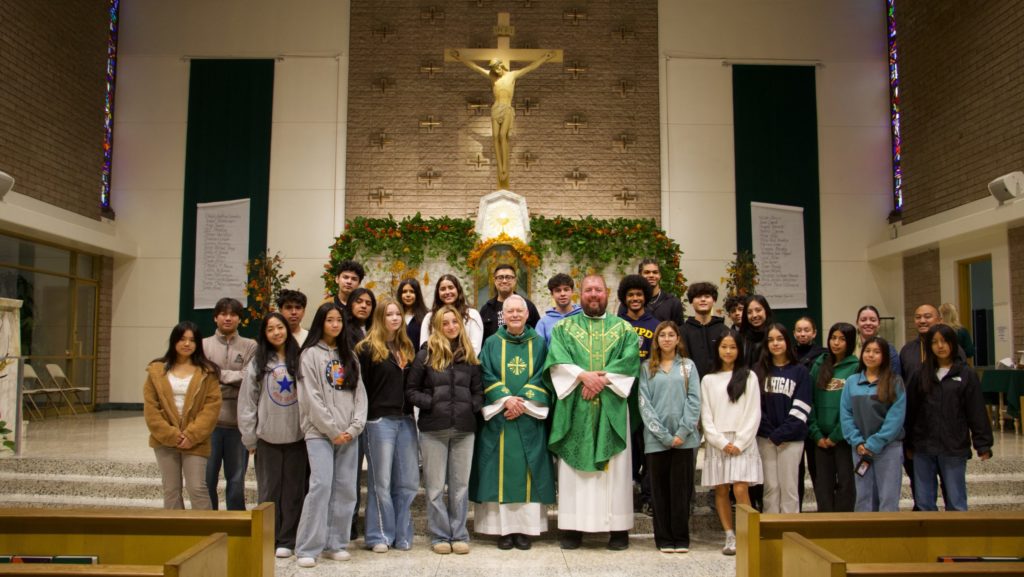 El obispo Matthew Elshoff, al centro, y el padre Max Villeneuve, OSA, párroco de Our Mother of Good Counsel en Los Feliz, posan con estudiantes de confirmación después de la Misa de “Stand Up Sunday” en la parroquia el 16 de noviembre. (Kimmy Chacón)