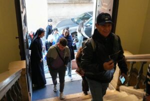 Peregrinos y turistas cruzan la puerta de la Oficina de Visitantes en Roma a comienzos de este año. (CNS/Lola Gomez)