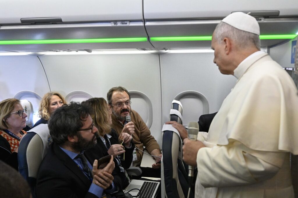 El Papa León XIV escucha una pregunta formulada por Gian Guido Vecchi, periodista del diario italiano Corriere della Sera, durante el vuelo de regreso del Líbano a Roma el 2 de diciembre de 2025. (Foto CNS/Vatican Media)