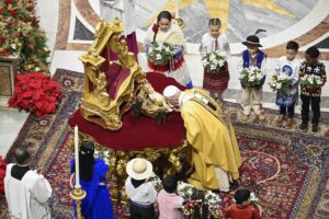 El Papa León XIV besa los pies de una estatua del Niño Jesús al comienzo de la Misa de Navidad en la Basílica de San Pedro en el Vaticano, la noche del 24 de diciembre de 2025. (Foto de CNS/Vatican Media)
