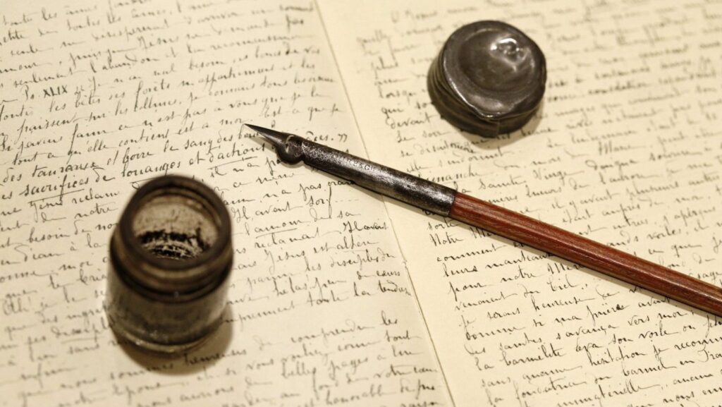 La pluma y el tintero usados por Santa Teresita de Lisieux descansan sobre un facsímil de páginas manuscritas de la santa, pertenecientes a su obra “Historia de un alma”. (CNS/Nancy Phelan Wiechec)