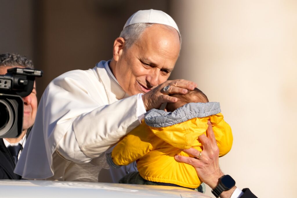 El papa León XIV saluda a un niño desde el papamóvil mientras recorre la plaza de San Pedro en el Vaticano antes de su audiencia general semanal el 31 de diciembre de 2025. (Foto CNS/Lola Gómez)