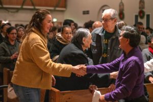 Feligreses de la iglesia del Sagrado Corazón en Altadena intercambian el saludo de la paz durante una Misa de sanación el 7 de enero de 2026, al cumplirse un año de los incendios en Los Ángeles. (John Rueda)