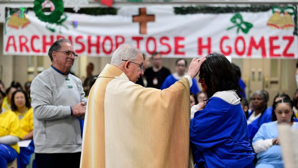 El arzobispo José H. Gómez bendice a una interna en el Centro Regional de Detención Century, la cárcel de mujeres más grande del condado de Los Ángeles, durante la Misa de Navidad el 25 de diciembre de 2025. (John McCoy)