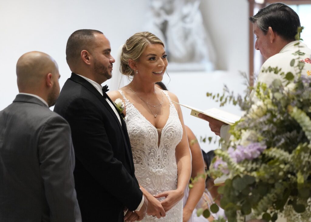Julio Prendergast y Christina MacDougall miran a monseñor Francis J. Schneider mientras oficia su boda el 20 de agosto de 2021 en la iglesia St. John the Baptist en Wading River, Nueva York (foto de OSV News/Gregory A. Shemitz).