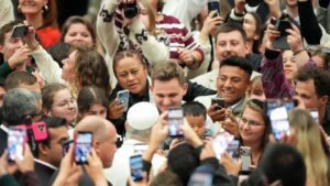 El Papa León XIV saluda a los fieles al inicio de su audiencia general semanal en el Aula Pablo VI el 11 de febrero de 2026. Carlos Martinez, estudiante de último año de Holy Innocents, aparece arriba a la derecha del pontífice. (CNS/Lola Gomez)