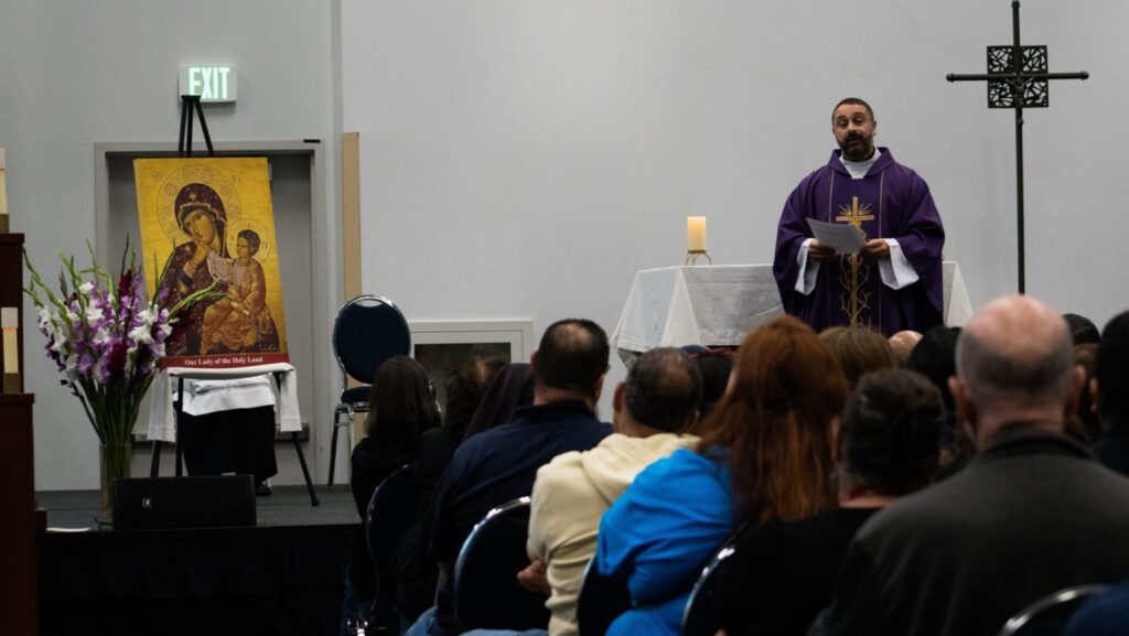 El padre Ala Musharbash, capellán de la Comunidad Católica Árabe Americana, con sede en St. Joseph Church en Pomona, pronuncia la homilía durante la primera Misa en árabe en el RECongress el 21 de febrero. (Katie Trejo)