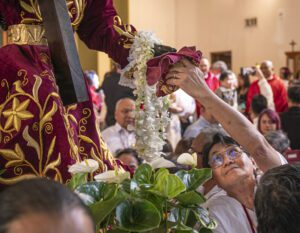 Una mujer toca la estatua del Nazareno Negro con su pañuelo burdeos, una tradición filipina que trae bendiciones al hacer contacto con un objeto sagrado. (Juanito Holandez Jr.)