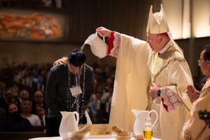El obispo auxiliar Timothy E. Freyer, de la Diócesis de Orange, bautiza a Jacob López durante la Vigilia Pascual en Holy Family Church en 2022. (CNS/Ian Tran, Diócesis de Orange)