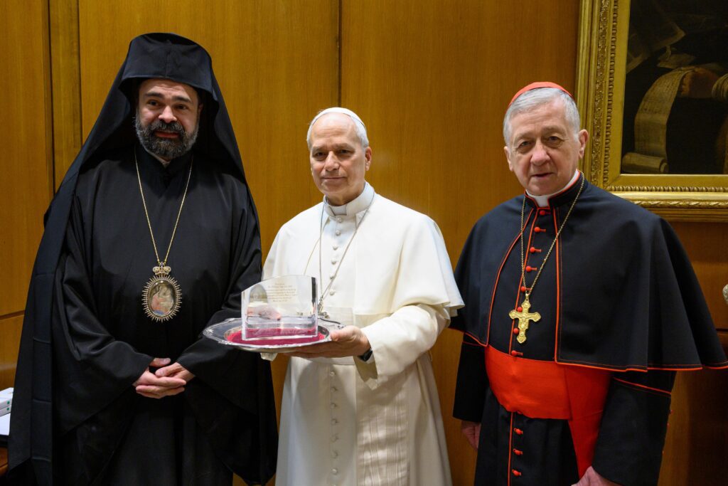 El papa León XIV sostiene un regalo mientras posa para una foto con el cardenal Blase J. Cupich, de Chicago, y el metropolitano ortodoxo griego Nathanael, de Chicago, durante una audiencia privada en el Vaticano el 4 de marzo de 2026. El cardenal y el metropolitano hicieron una parada en Roma como parte de una peregrinación ecuménica conjunta para celebrar el 1700 aniversario del Concilio de Nicea. (Foto CNS/Vatican Media)