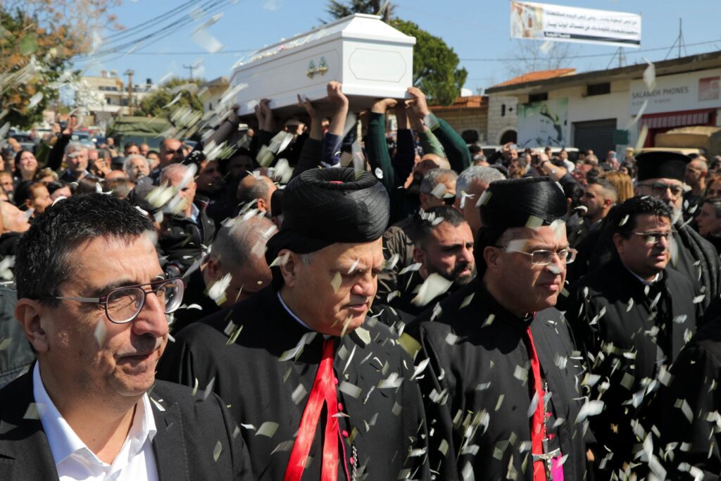 Miembros del clero participan en una procesión mientras la gente lleva el féretro del padre Pierre al-Rahi durante su funeral en Qlayaa, en el sur del Líbano, el 11 de marzo de 2026. El sacerdote católico maronita libanés falleció el 9 de marzo tras sufrir heridas por el fuego de un tanque israelí contra una casa en Qlayaa, tras una escalada entre Hezbolá e Israel en medio de la guerra entre Estados Unidos e Israel con Irán. (Foto de OSV News/Karamallah Daher, Reuters)