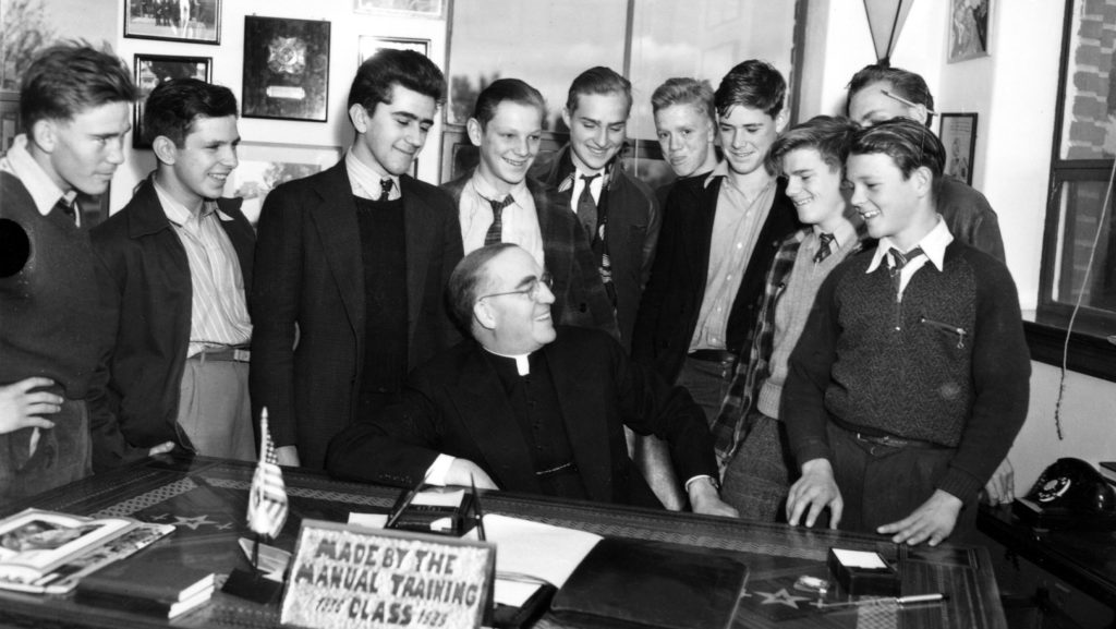 En esta fotografía de 1942, el padre Edward Flanagan aparece rodeado de jóvenes en su despacho de Boys Town, en Omaha (Nebraska). El 23 de marzo de 2026, el papa León XIV declaró «venerable» al padre Flanagan, fundador de Boys Town, en reconocimiento a sus virtudes heroicas. (Foto de OSV News / Cortesía de Boys Town)
